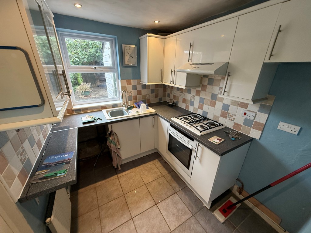 Lot: 76 - TWO-BEDROOM MID-TERRACE HOUSE FOR IMPROVEMENT - Kitchen with fitted units, window and door to conservatory